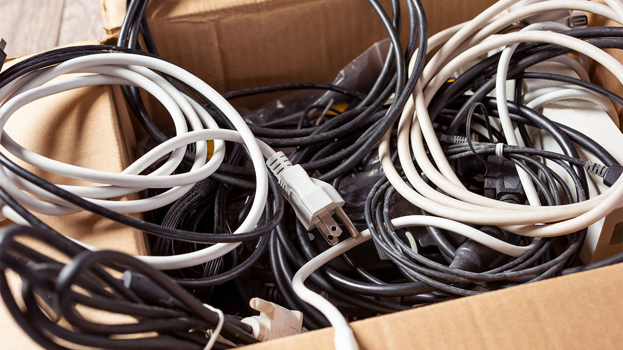 coiled-up electronics cords in a brown cardboard box
