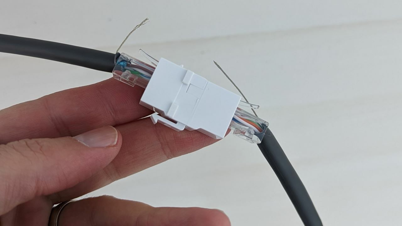 Cable ends joined by a Cat 6 cable coupler