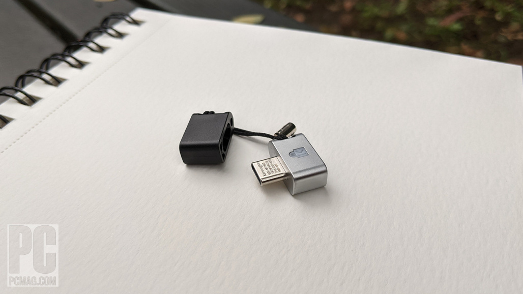 The Kensington VeriMark Guard USB-C Fingerprint Key sitting on an open notebook