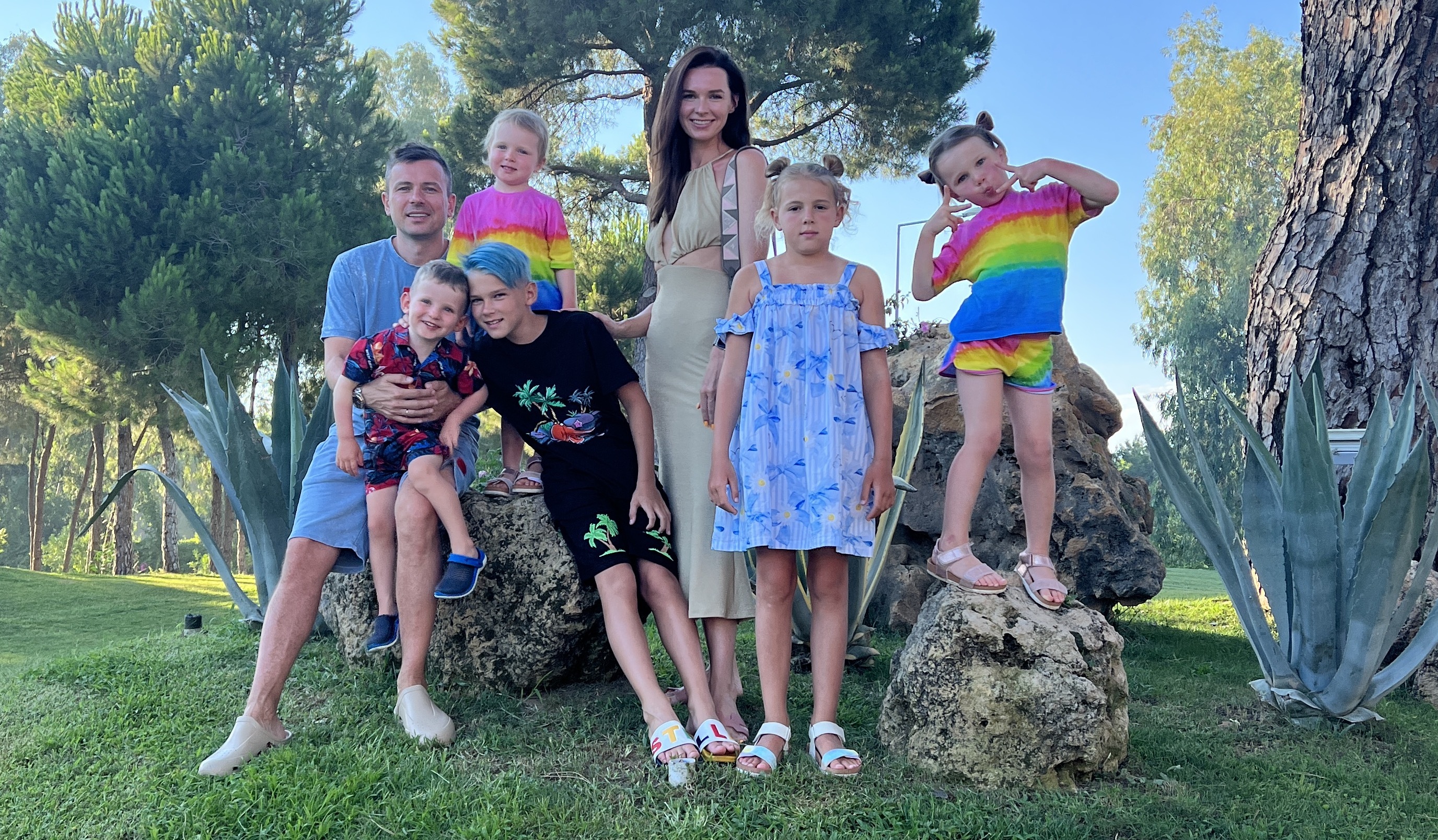 Five children and two adults outside posing for a family photo