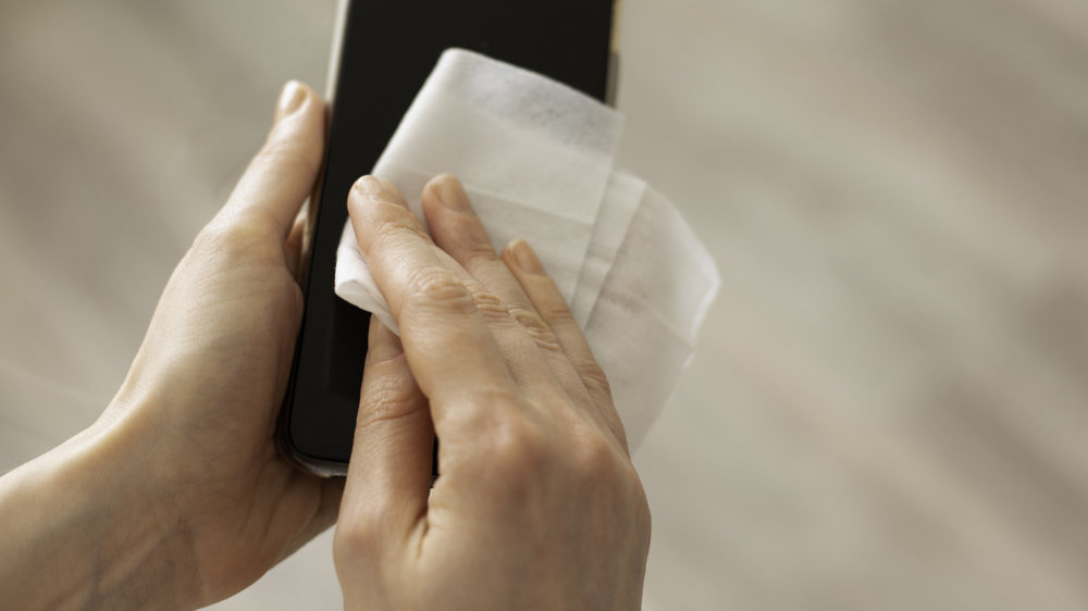 person using a wipe on a phone screen
