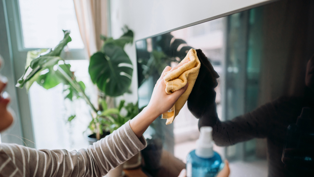 Close up of woman cleaning TV screen 