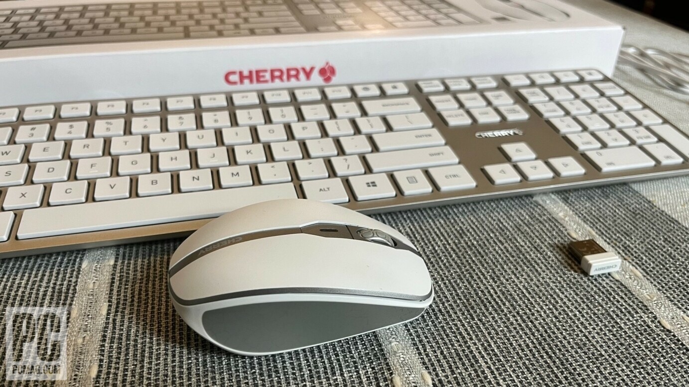 Cherry Keyboard, mouse, and box sitting on a table.
