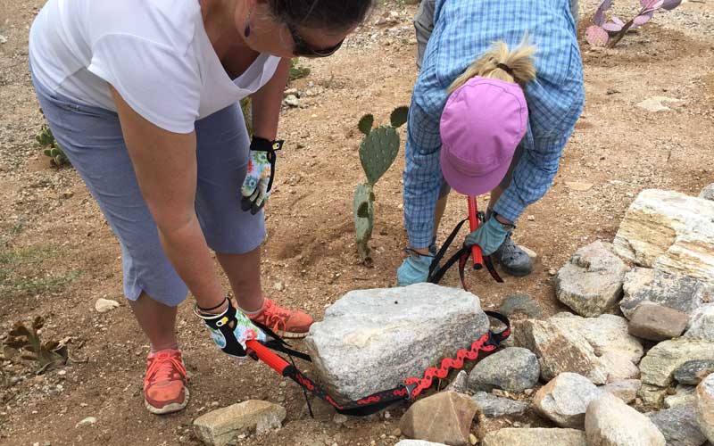 Wrapping PotLifter straps around a rock